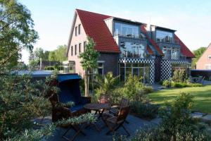 a house with a table and chairs in front of it at Haus in der Duene _ Objekt 25954 in Warnemünde
