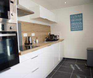 une cuisine avec des placards blancs et un comptoir dans l'établissement Mézières House, à Tourcoing