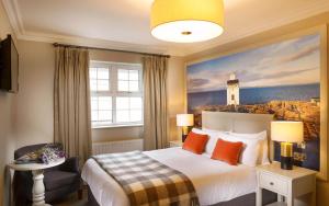 a bedroom with a bed with a painting of a lighthouse at The Wild Atlantic Lodge in Ballyvaughan