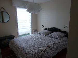 um quarto com uma cama com duas almofadas e uma janela em Appartement 3 pièces coeur de ville em Lorient