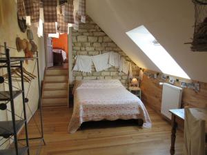 - une chambre avec un lit et un mur en pierre dans l'établissement Chambres d'hôtes Les Arondelles, à Virey-le-Grand