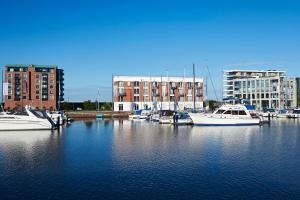 un grupo de barcos atracados en un puerto con edificios en Im-Jaich Hotel Bremerhaven en Bremerhaven