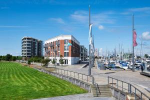 a marina with boats in the water and a building at Im-Jaich Hotel Bremerhaven in Bremerhaven