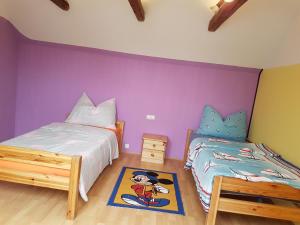 1 dormitorio con 2 camas y pared púrpura en Lukas Oscar, en Bad Blumau
