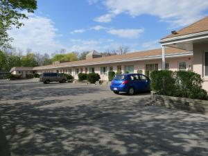 une voiture bleue garée devant un bâtiment dans l'établissement Clarkson Village Motel, à Mississauga