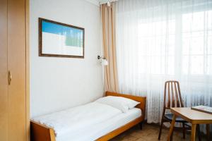 a bed in a room with a desk and a window at Hotel Am Brillantengrund in Vienna