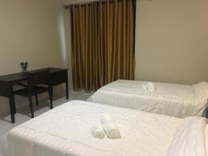 a hotel room with two beds and a desk at Maerim Hostel in Chiang Mai