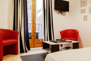 バルセロナにあるNice apartment in the middle of Bornの椅子2脚、ベッド1台、窓が備わる客室です。