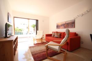 sala de estar con sofá rojo y TV en Apartment Puerto Colon en Adeje