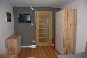 a bedroom with a bed and a tv on the wall at Apartament Rodzinny in Szklarska Poręba