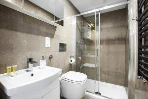 a bathroom with a toilet and a sink and a shower at Apartament Wyzwolenia - Unique Apartments in Szczecin +11 photos
