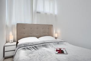 a bedroom with a bed with a book on it at Apartament Wyzwolenia - Unique Apartments in Szczecin