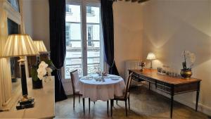 a dining room with a table and a desk and a window at Les chambres de l'Abbaye in Caen