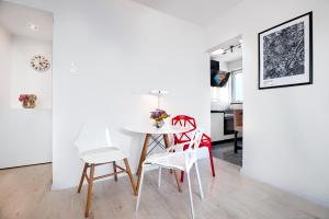 a dining room with a white table and chairs at Apartament Wyzwolenia - Unique Apartments in Szczecin