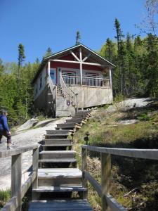 a man walking up the stairs to a building at Chalet de la Montagne in Tadoussac