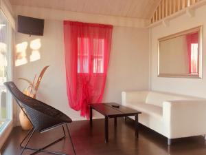 ein Wohnzimmer mit einem weißen Sofa und roten Vorhängen in der Unterkunft Playa Di Valverde in Galliate