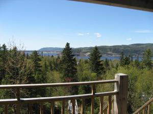 a view from the deck of a cabin overlooking the water at Chalet de la Montagne in Tadoussac