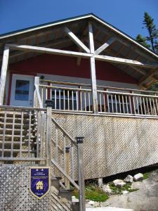 a house with a cross on the front of it at Chalet de la Montagne in Tadoussac