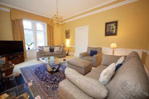 ein Wohnzimmer mit einem Sofa und einem TV in der Unterkunft Lochwood Guest House in Lochgoilhead
