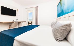 a hotel room with a bed and a television at Globales Santa Lucia - Adults Only 18 in Palmanova