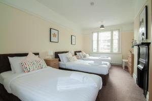 a bedroom with two beds and a tv at The Jollys in Bootle