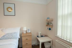 1 dormitorio con 1 cama y 1 mesa con mesita de noche en The Jollys, en Bootle