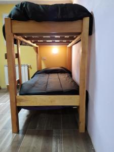 a bunk bed with a black mattress on top of it at Hostel Familia de Campo in El Chalten