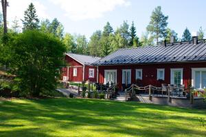 a red house with a yard in front of it at Hotel Hiisi Hill in Jämsä