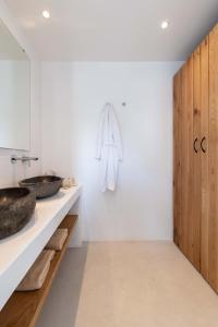 a bathroom with a sink and a towel rack at Trinity Mykonos - Villa & Beachfront Boutique Hotel in Platis Gialos