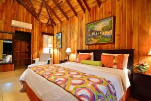 a bedroom with a large bed and a painting on the wall at Hotel Lomas del Volcan in Fortuna