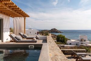 a villa with a pool and a view of the ocean at Trinity Mykonos - Villa & Beachfront Boutique Hotel in Platis Gialos