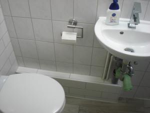 a white toilet sitting next to a sink in a bathroom at Apartment Schulz in Berlin