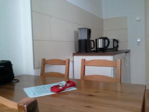 a wooden table topped with a coffee cup next to a microwave at Apartment Schulz in Berlin