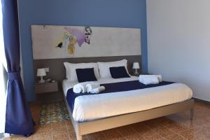 a bedroom with a large bed with blue walls at Specchio di Parthenope B&B in Naples