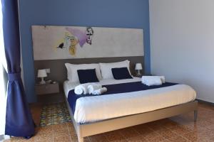 a bedroom with a large bed with blue walls at Specchio di Parthenope B&B in Naples