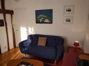 a living room with a blue couch and a table at L'Orée de Versailles in Versailles