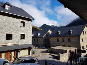 a group of buildings with mountains in the background at Apartamentos Nilsson, Casa Botigue, centro de Plan in Plan