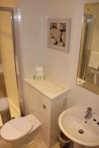 Un baño blanco con inodoro y lavabo. en Empire Serviced Apartments, en Leicester 37 fotos más