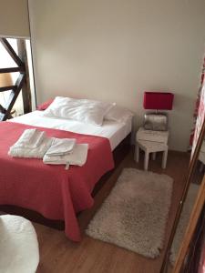 a bedroom with a bed with red sheets and white towels at LX Pena Apartment in Lisbon