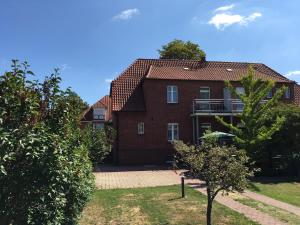 a red brick house with a balcony in a yard at Pension Sellent in Stendal