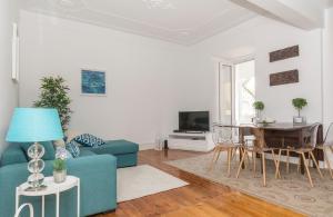 ein Wohnzimmer mit einem blauen Sofa und einem Tisch in der Unterkunft Lisbon City Center in Lissabon