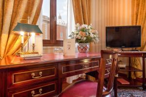 a room with a desk with a television and a lamp at Residenza Paolo VI in Rome
