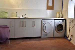 una cucina con lavatrice e lavandino di L'Olivier a Néffiès