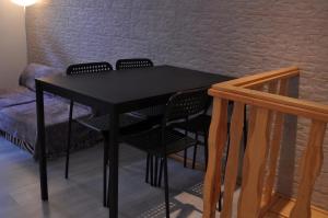 ヴィラ・ノヴァ・デ・ガイアにあるOporto2All Apartments - Apt3のレンガの壁の横に椅子付きの黒いテーブル