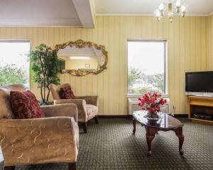 sala de estar con sofá, TV y mesa en Econo Lodge Inn & Suites, en Lugoff