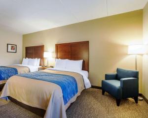 a hotel room with two beds and a chair at Comfort Inn at Royal Blue in Pioneer
