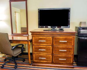 a television on a dresser with a desk and a chair at Econo Lodge Jefferson Hills Hwy 51 in Clairton