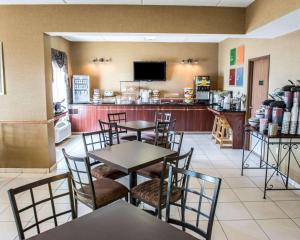 um restaurante com mesas e cadeiras e um bar em Wingate by Wyndham Grove City em Grove City