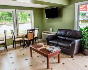 a living room with a leather couch and a table at Econo Lodge Jefferson Hills Hwy 51 in Clairton