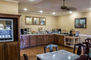 a kitchen with wooden cabinets and a table and chairs at Quality Inn Kingsport South in Kingsport